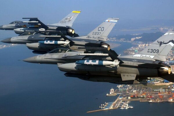 Several military planes over the sea and the city