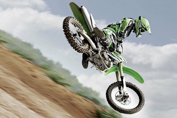 The flight of a motorcyclist in green gear against the sky