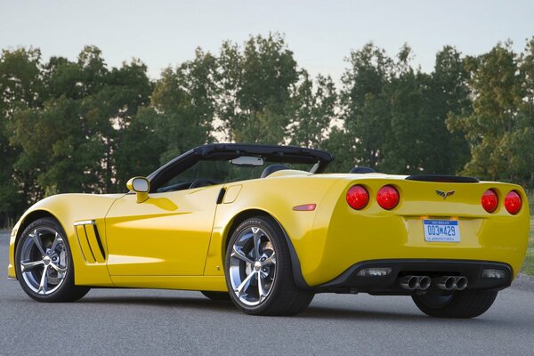 Yellow corvette on the road with chrome wheels