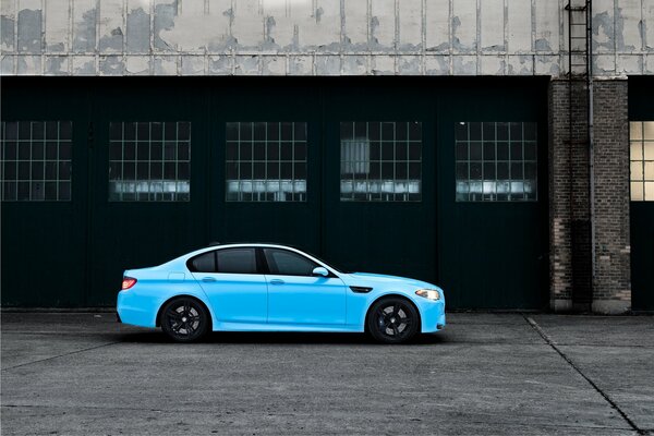 BMW bleue et vieille usine