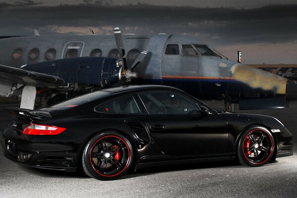 Porsche negro en el fondo del avión por la noche