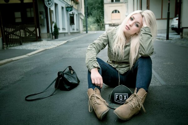 Chica en jeans en el asfalto espera la felicidad