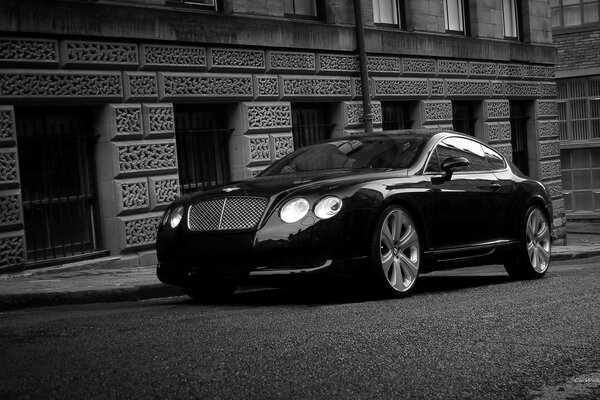 A black car is parked outside the building