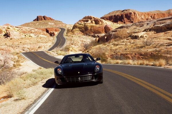 A black Ferrari is driving on the road