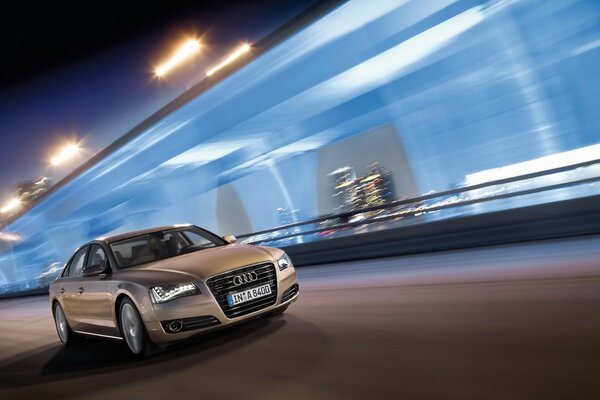 Audi in the middle of the night city rushes at speed