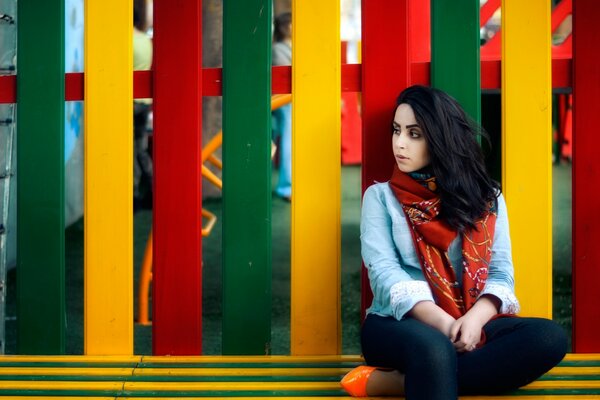 Femme triste sur fond coloré de clôture