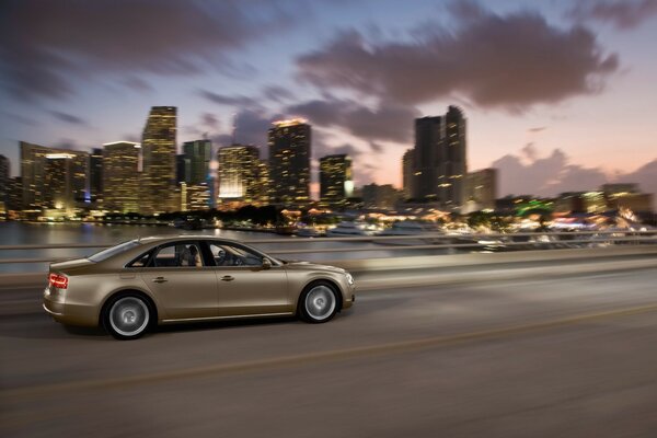 Audi A8 che corre lungo la pista sullo sfondo del tramonto