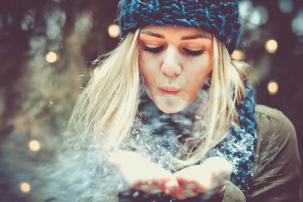 Blonde bläst Schnee aus Ihren Handflächen