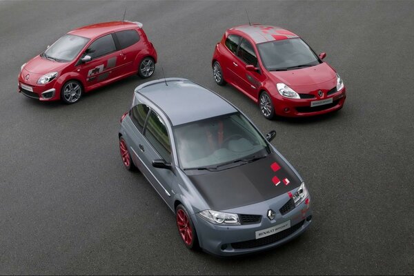 3 coches renault megane están en el asfalto