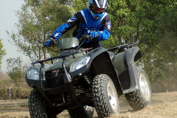 Le VTT Kymco laisse derrière lui un léger nuage de poussière pendant la conduite