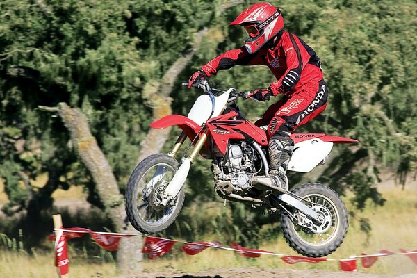 Sprung auf einem roten Cross-Motorrad