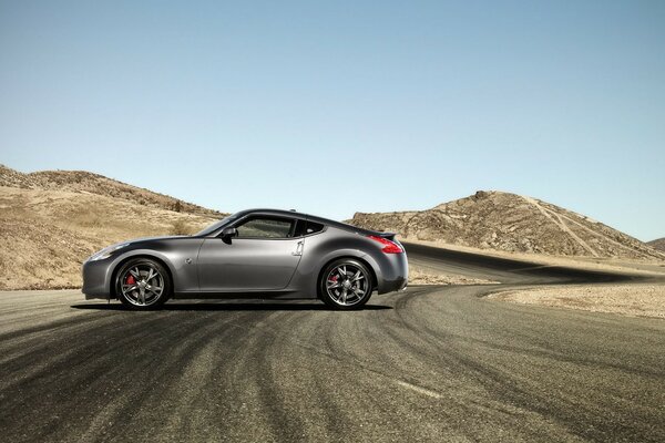 Gris nissan 370Z sur la route dans le désert