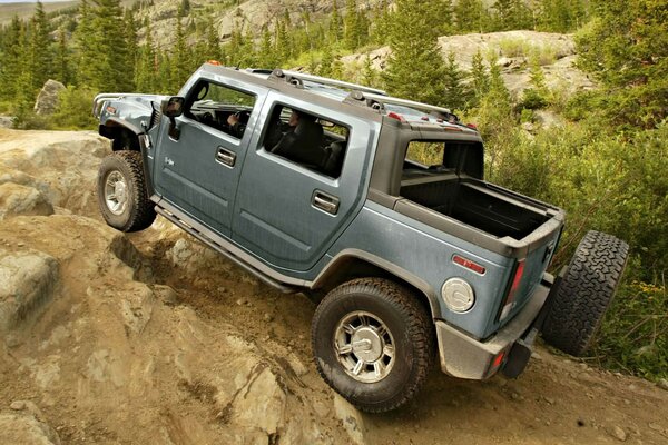 Hummer grimpe sur une haute falaise rocheuse