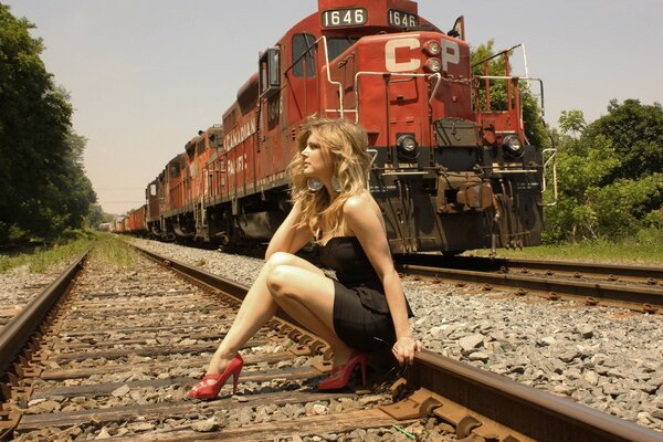 Young blonde posing on the railway track