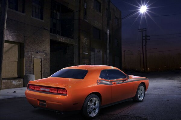 Dodge naranja en la calle nocturna