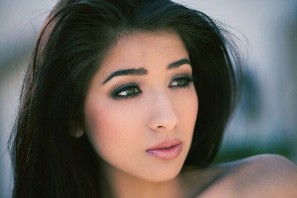 Brunette with long hair and almond-shaped eyes