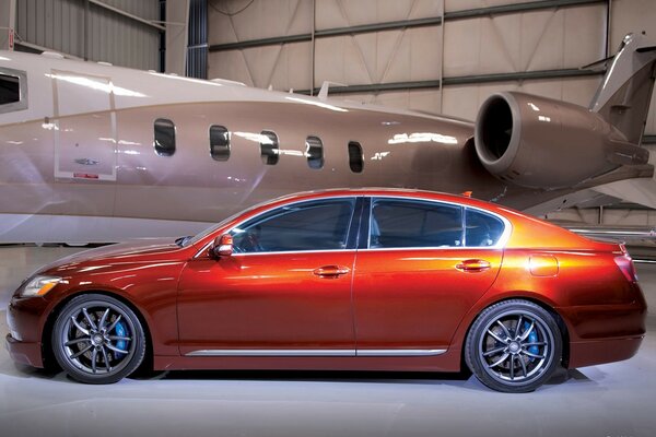 Auto lexus gs-350 sullo sfondo di un aereo in un hangar