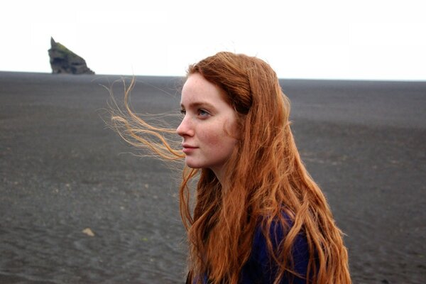 A red-haired girl among a gray field