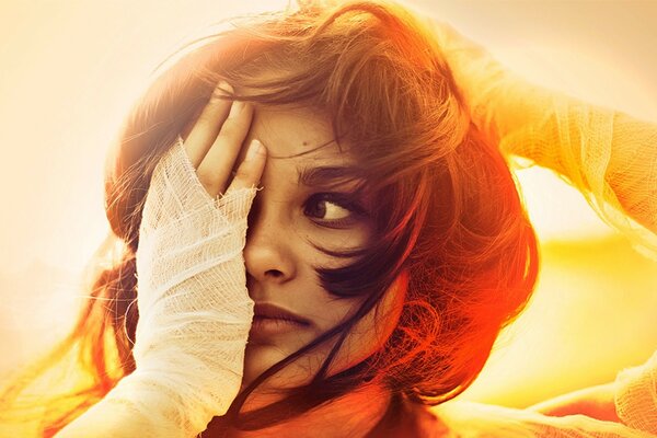 A girl on the background of the sunset. Yellow background, wind fluttering hair