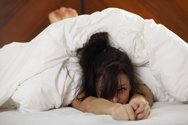 Sexy girl in bed under a blanket