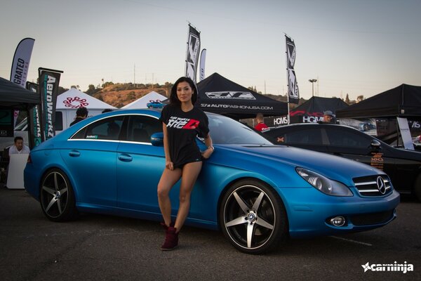 Sexy asiatische Frau in der Nähe eines blauen mercedes