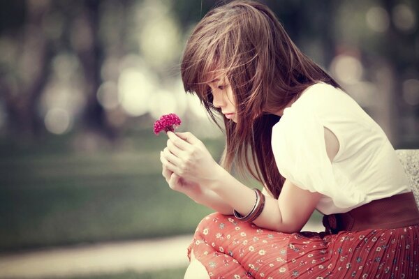 Brune triste avec une fleur dans les mains