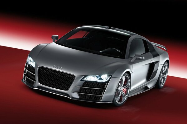 Coche Audi R8 gris con los faros encendidos