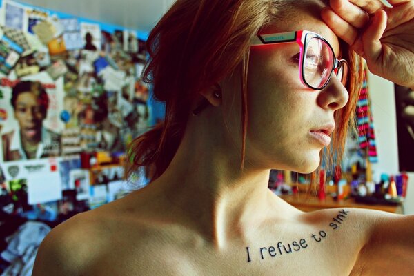 Rousse fille avec un tatouage sur la clavicule