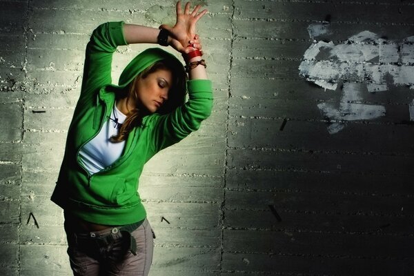 A girl in a green jacket dancing