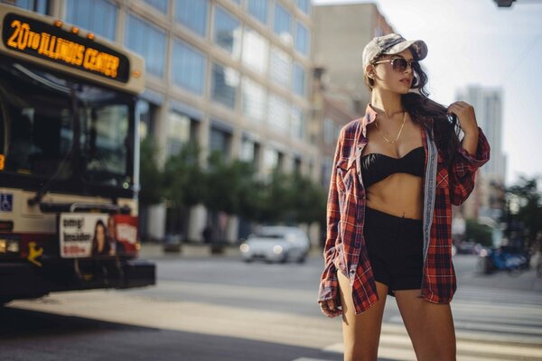 A girl at the city bus station near the bus