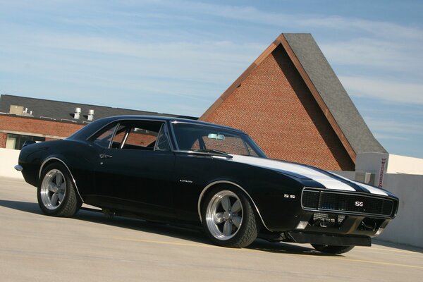 Black cevrole camaro ss with white stripes on the hood