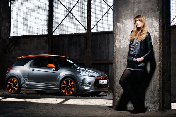 Una chica de pie junto a un coche de carreras con un DS3