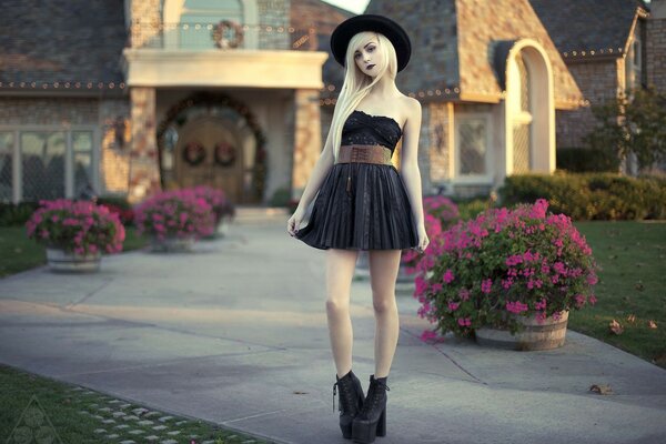 A girl in a black dress near the house