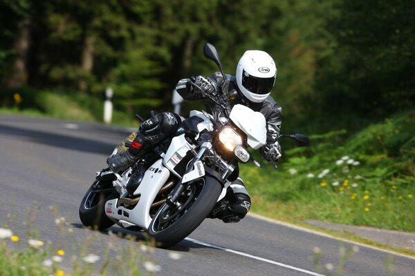 Motorradfahrer fährt in einer Grube zwischen Blumen