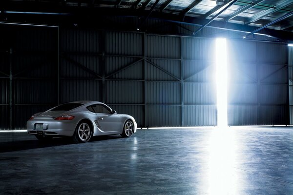 A silver Porsche pulls out of the garage