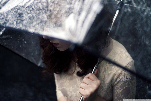 Fille sous un parapluie en robe blanche