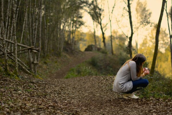 Chica sentada en el bosque de espaldas