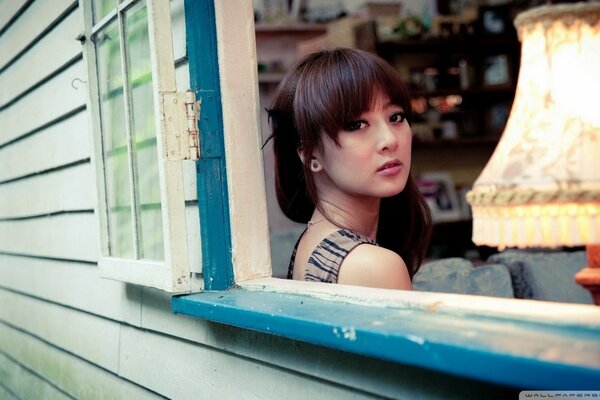 Asian girl sitting by the window