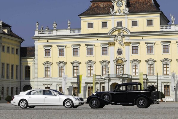 White maybach and a black car on the background of the building