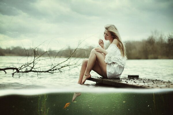 A girl in a white dress photographed by the lake