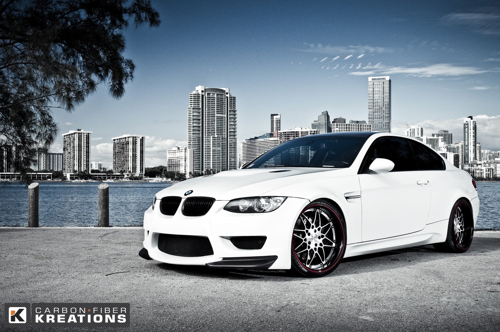 bmw m3 e92 bmw voiture de sport voiture de sport blanc carbone tuning jantes bavière allemagne auto voiture transport voiture voiture blanche ville gratte-ciel bâtiments ciel maisons rivière colonnes bois asphalte véhicules