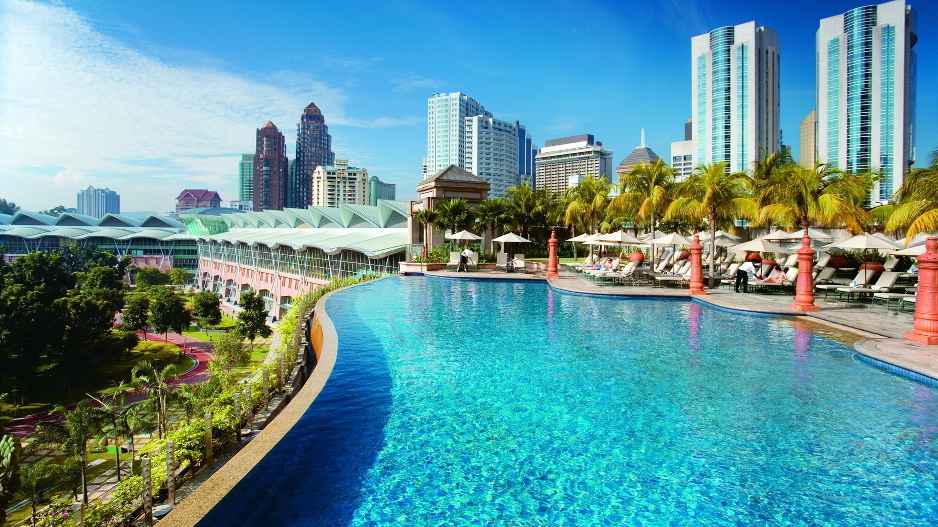 kuala lumpur fiori malesia hotel piscina acqua turchese palme edifici case città vacanze cielo grattacieli giorno giornata di sole vegetazione vegetazione ombrelloni sedie a sdraio alberi