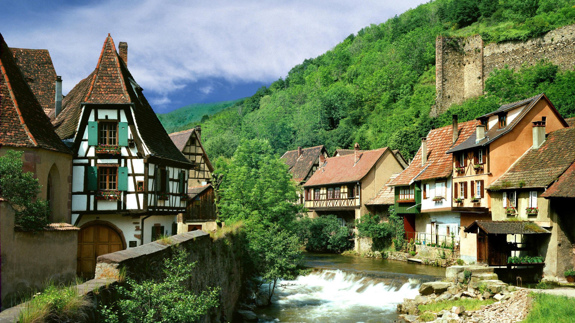 a house near the water summer landscape mountains greens vegetation thickets home river for the village the sky clouds roof