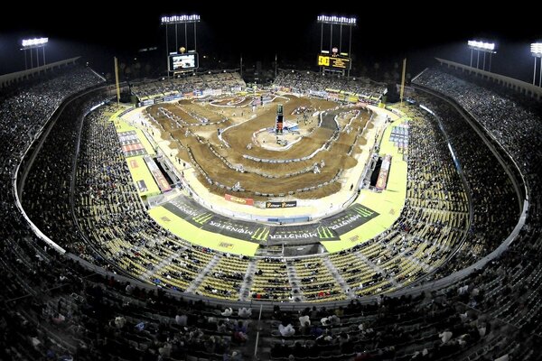 Motorcycle racing at the stadium with a bunch of spectators