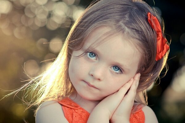 Foto del modello del bambino con fiocco rosso