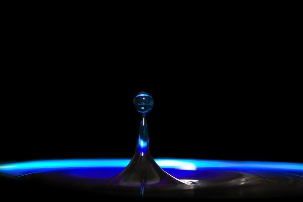 A drop of liquid is drawn out on a black background