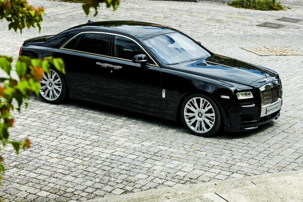 El clásico coche negro de la marca rolls royce con luz natural