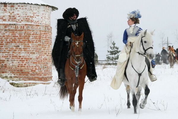 Mezhchina and a woman walk on horseback in winter