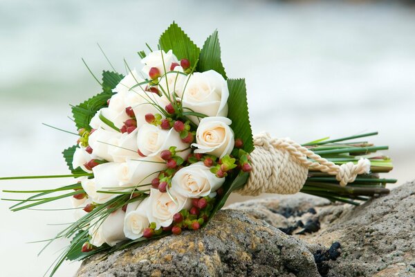 Ramo de novia de rosas blancas sobre piedras