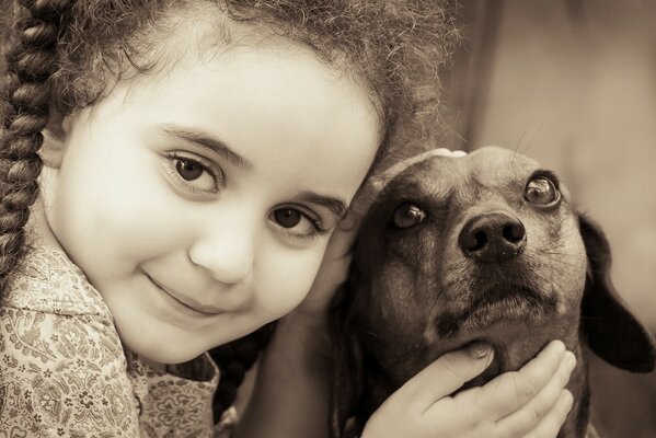 A little girl stroking a small dog